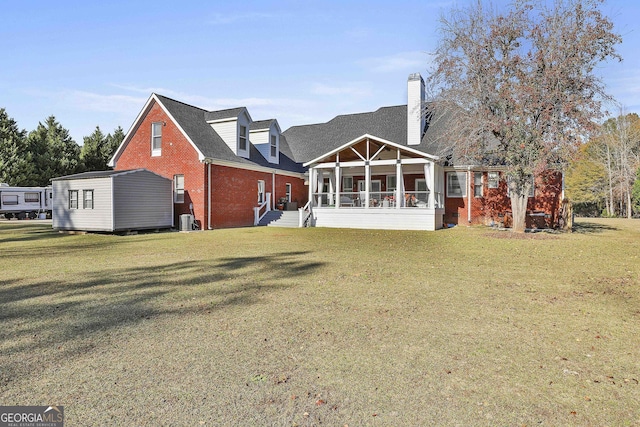 back of property with a sunroom and a lawn