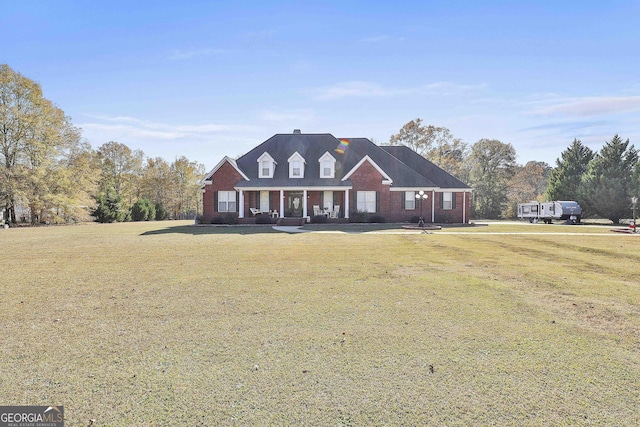 new england style home with covered porch and a front yard