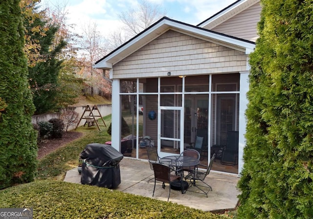 rear view of house featuring a patio and a sunroom