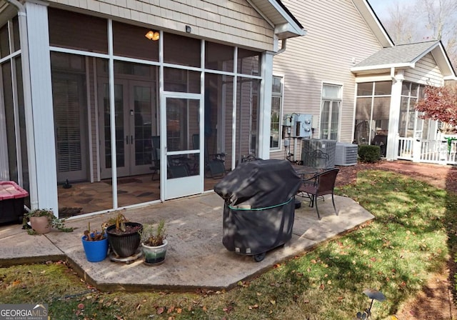 view of patio featuring french doors, central air condition unit, area for grilling, and a sunroom