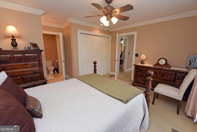 carpeted bedroom featuring crown molding, ensuite bath, ceiling fan, and a closet