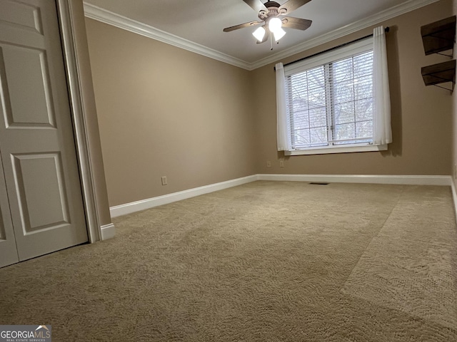 carpeted spare room featuring ceiling fan and ornamental molding