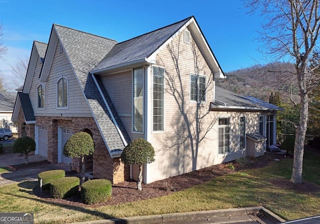 view of side of home featuring a yard and a garage