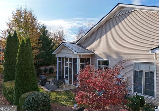 exterior space featuring a patio area and a sunroom