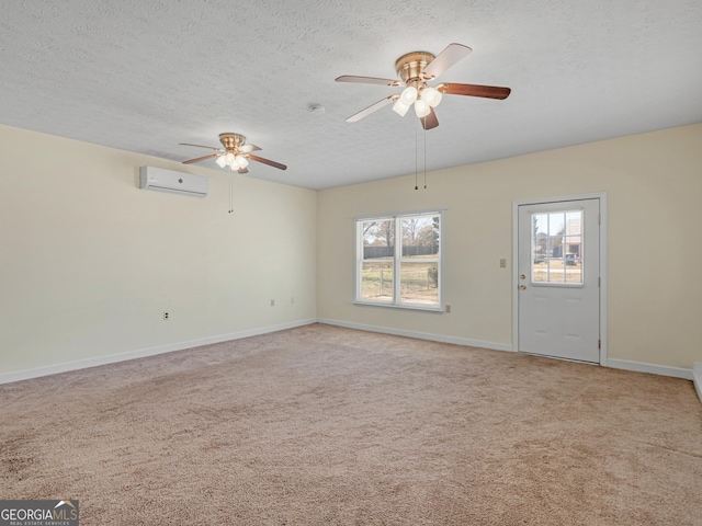 unfurnished living room featuring a textured ceiling, a wall mounted air conditioner, baseboards, and light colored carpet