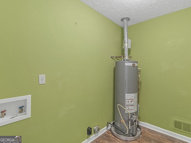 utility room featuring gas water heater and visible vents