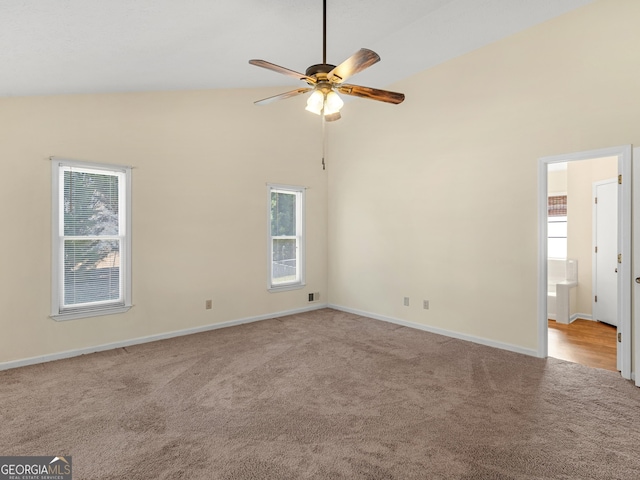 empty room featuring light carpet, ceiling fan, high vaulted ceiling, and baseboards