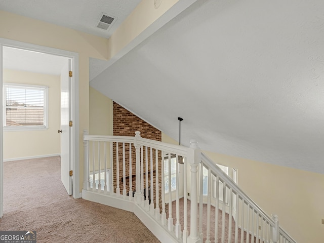 corridor with lofted ceiling, baseboards, visible vents, and carpet flooring