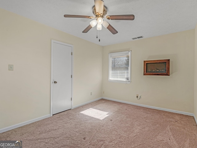 empty room with carpet flooring, visible vents, and baseboards