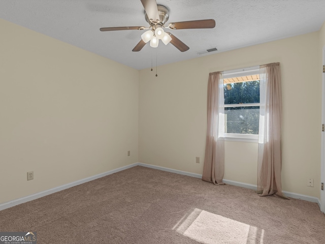 empty room featuring visible vents, light carpet, baseboards, and a textured ceiling