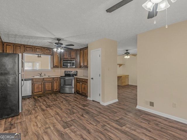 kitchen with stainless steel appliances, dark wood-style flooring, light countertops, and a sink