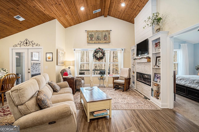 living room featuring hardwood / wood-style floors, french doors, wood ceiling, and a large fireplace