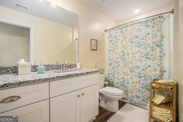 bathroom featuring vanity, hardwood / wood-style flooring, curtained shower, and toilet