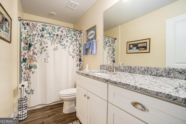 bathroom with vanity, toilet, and hardwood / wood-style floors