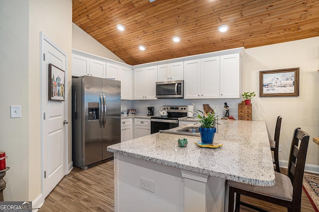 kitchen with wooden ceiling, white cabinets, appliances with stainless steel finishes, and kitchen peninsula