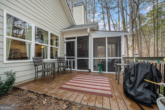 deck with a sunroom and grilling area