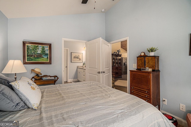 bedroom featuring ceiling fan, stainless steel fridge with ice dispenser, high vaulted ceiling, and ensuite bathroom