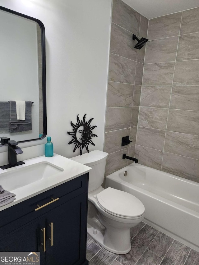 full bathroom featuring vanity, tiled shower / bath combo, and toilet