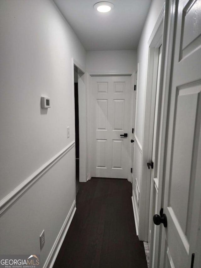 corridor with dark hardwood / wood-style flooring