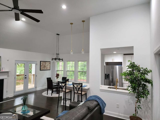 living room with a towering ceiling, dark hardwood / wood-style floors, and ceiling fan