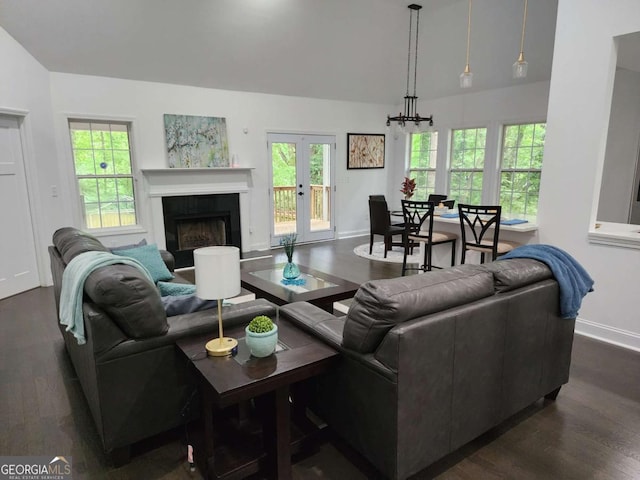 living room featuring french doors, dark hardwood / wood-style flooring, and an inviting chandelier