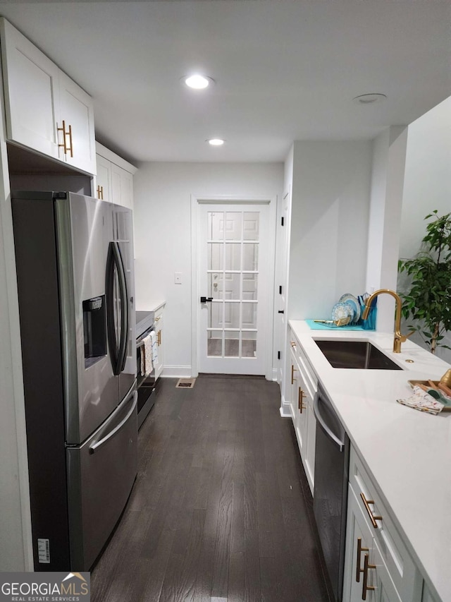 kitchen featuring white cabinets, appliances with stainless steel finishes, dark hardwood / wood-style floors, and sink