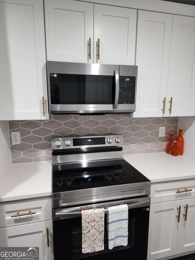 kitchen with decorative backsplash, white cabinetry, and stainless steel appliances