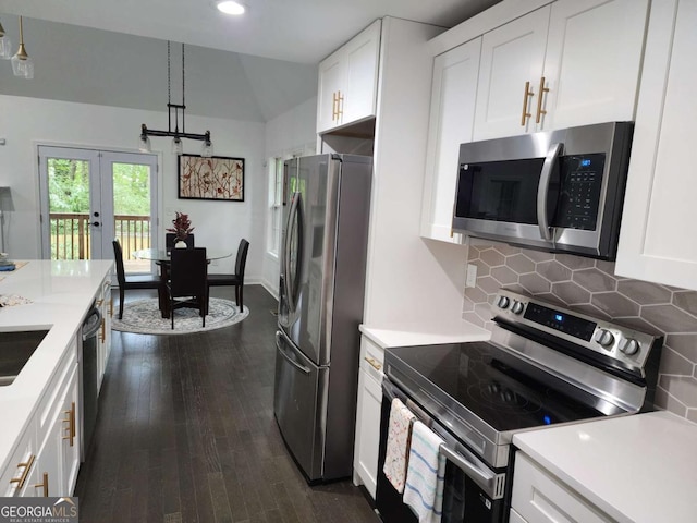 kitchen featuring dark wood-type flooring, stainless steel appliances, backsplash, pendant lighting, and white cabinets