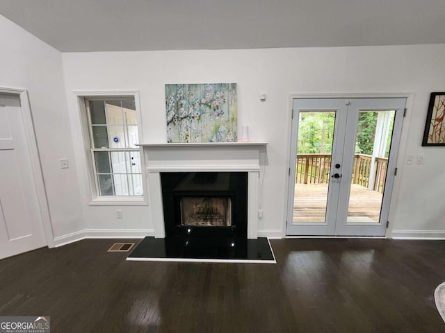 unfurnished living room with dark wood-type flooring and french doors