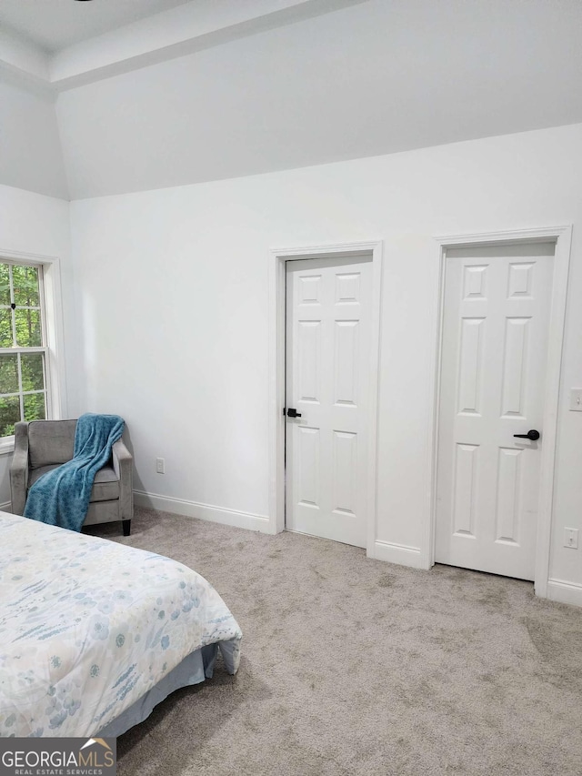 carpeted bedroom with lofted ceiling