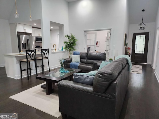 living room featuring dark hardwood / wood-style floors and a towering ceiling