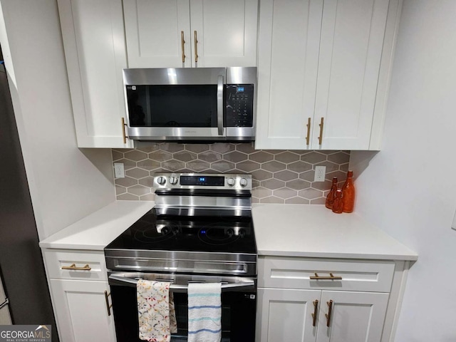 kitchen with backsplash, white cabinetry, and appliances with stainless steel finishes