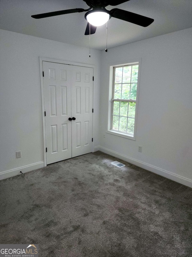 unfurnished bedroom featuring carpet, a closet, and ceiling fan