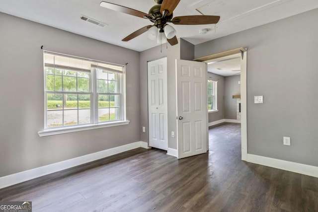 unfurnished bedroom with ceiling fan and dark wood-type flooring