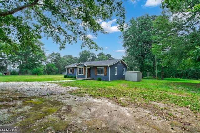 single story home featuring a storage shed and a front yard