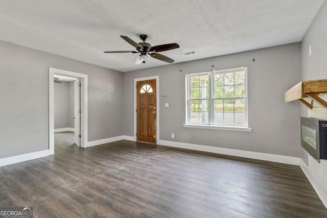 entrance foyer featuring ceiling fan, dark wood-type flooring, and a textured ceiling