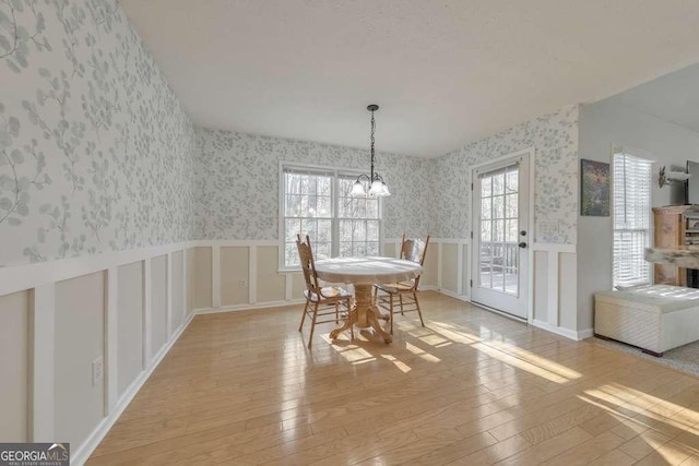 dining room featuring an inviting chandelier, light hardwood / wood-style flooring, and a healthy amount of sunlight