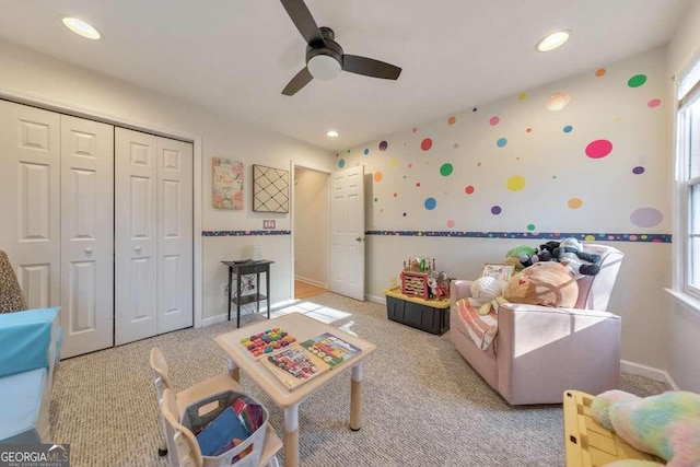 rec room with ceiling fan, light colored carpet, and a wealth of natural light