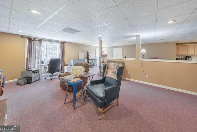 living area with carpet floors and a paneled ceiling