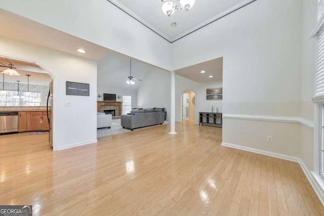 unfurnished living room featuring ceiling fan, light hardwood / wood-style flooring, and a towering ceiling