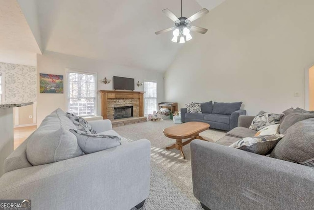 carpeted living room featuring ceiling fan, a fireplace, and high vaulted ceiling