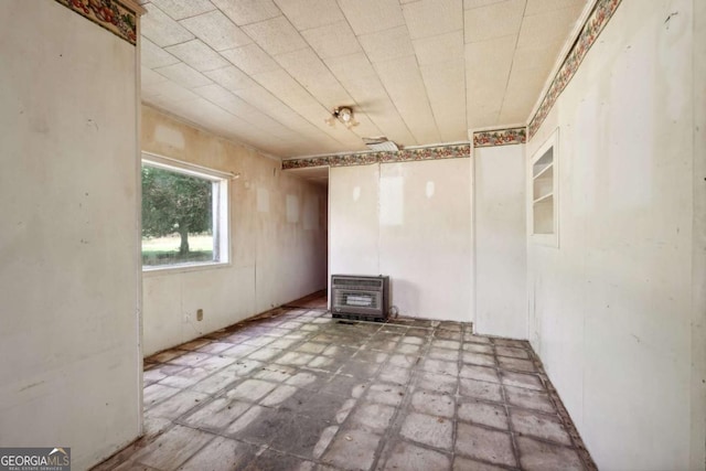 unfurnished room featuring heating unit