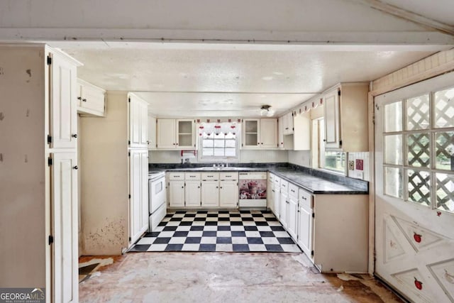 kitchen with dishwashing machine, white electric range oven, white cabinetry, and sink