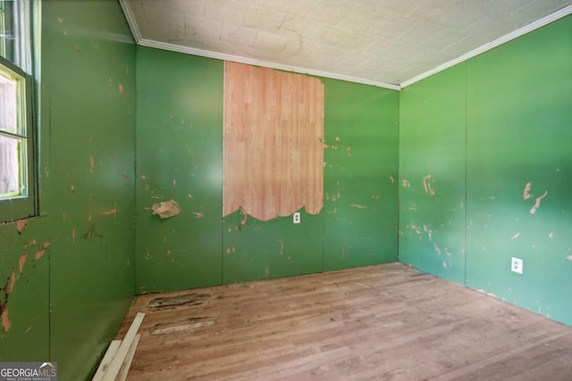 empty room featuring hardwood / wood-style floors and ornamental molding