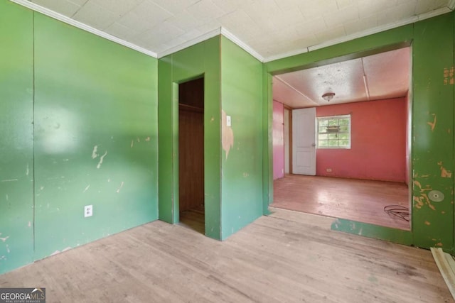 empty room featuring hardwood / wood-style floors and ornamental molding