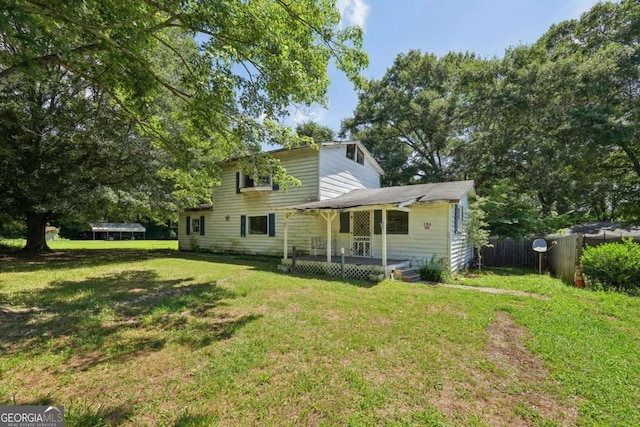 rear view of house with a yard, a trampoline, and a deck