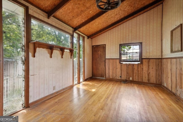 unfurnished sunroom featuring vaulted ceiling with beams