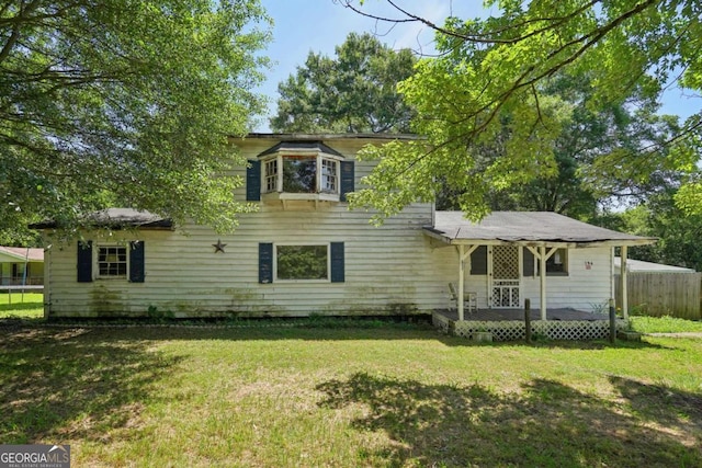 back of house with a lawn and a deck