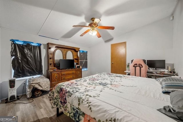 bedroom with ceiling fan, vaulted ceiling, and hardwood / wood-style flooring