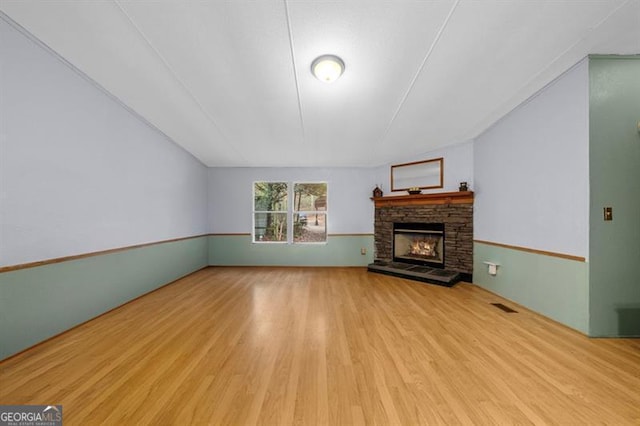 unfurnished living room featuring a fireplace and light hardwood / wood-style flooring